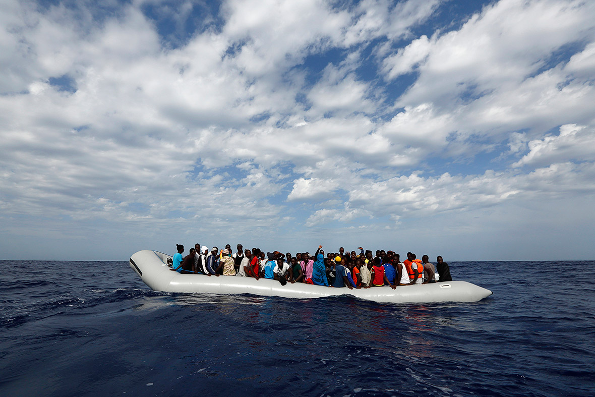 A rubber dinghy with 104 people on board waiting to be rescued is seen some 25 miles off the Libyan coast.