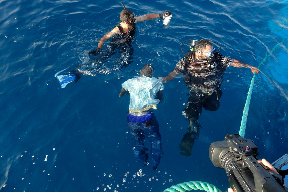 Members of Libya's coast guard recover the body of a migrant off the coast of Tripoli.