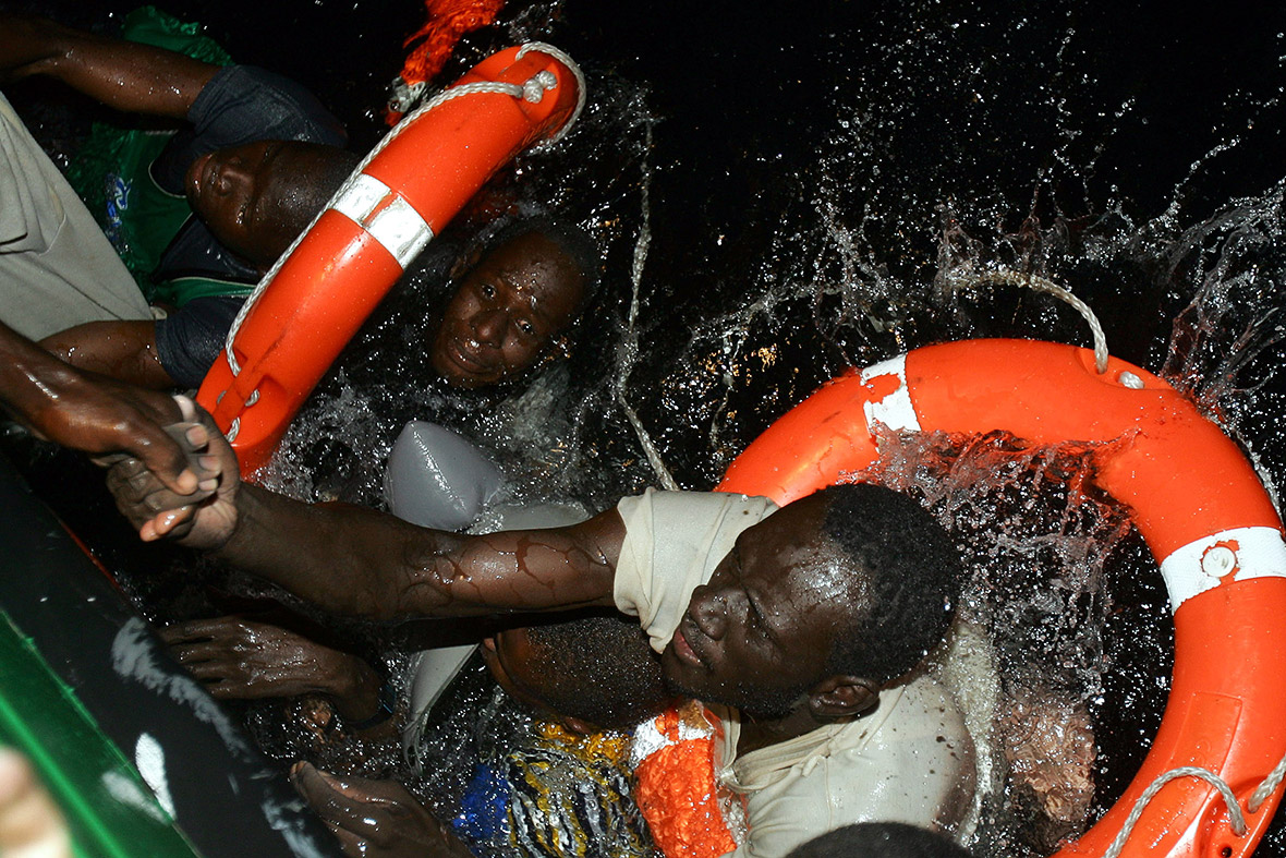 Migrants try to climb aboard a Spanish civil guard vessel after their makeshift boat capsized during a rescue operation at sea off the coast of Fuerteventura.