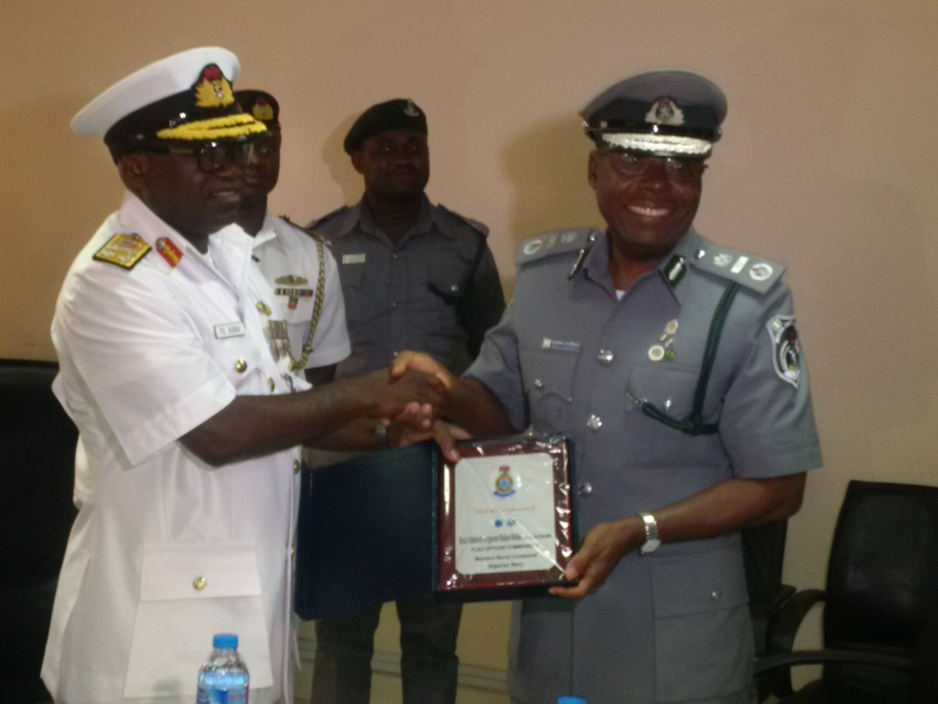 Zonal Coordinator in charge of Zone 'A' of the Nigeria Customs Service, Assistant Comptroller General (ACG) Charles Edike ( left) presenting a plaque to Flag Officer Commanding (FOC) Western Naval Command, Rear Admiral Ferguson Bobai when Bobai visited Edike at the zonal headquarters in Lagos on Wednesday.