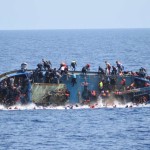 Migrants are seen on a capsizing boat before a rescue operation by Italian navy ships "Bettica" and "Bergamini" (unseen) off the coast of Libya