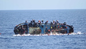 Migrants are seen on a capsizing boat before a rescue operation by Italian navy ships "Bettica" and "Bergamini" (unseen) off the coast of Libya