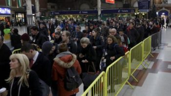 Passengers queue up for an express train to Gatwick Airport, running a reduced service as a result of a train strike, in Victoria rail station London.