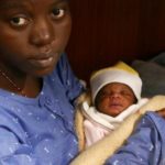 Nigerian migrant Mariam holds her baby girl aboard a rescue vessel