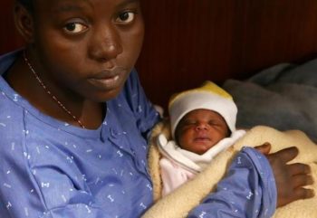 Nigerian migrant Mariam holds her baby girl aboard a rescue vessel