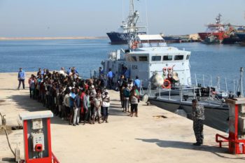 Migrants line up upon their arrive at a naval base after they were rescued by Libyan coastguard, in Tripoli
