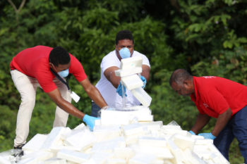 Police officers in plain clothes arrange packages of cocaine, seized from a ship stopped in international waters, before their incineration at a military base in Santo Domingo