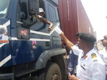 The Commander, Nigerian Navy Ship(NNS) BEECROFT, Commodore Okon Eyo, giving the call up card to a truck driver in Apapa.  