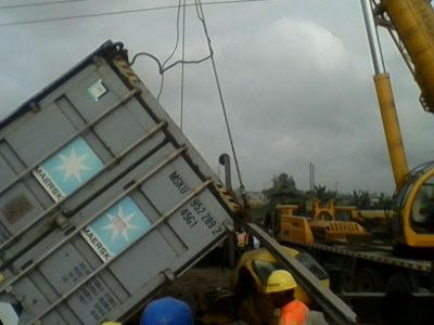 Container falls off truck, crushes two